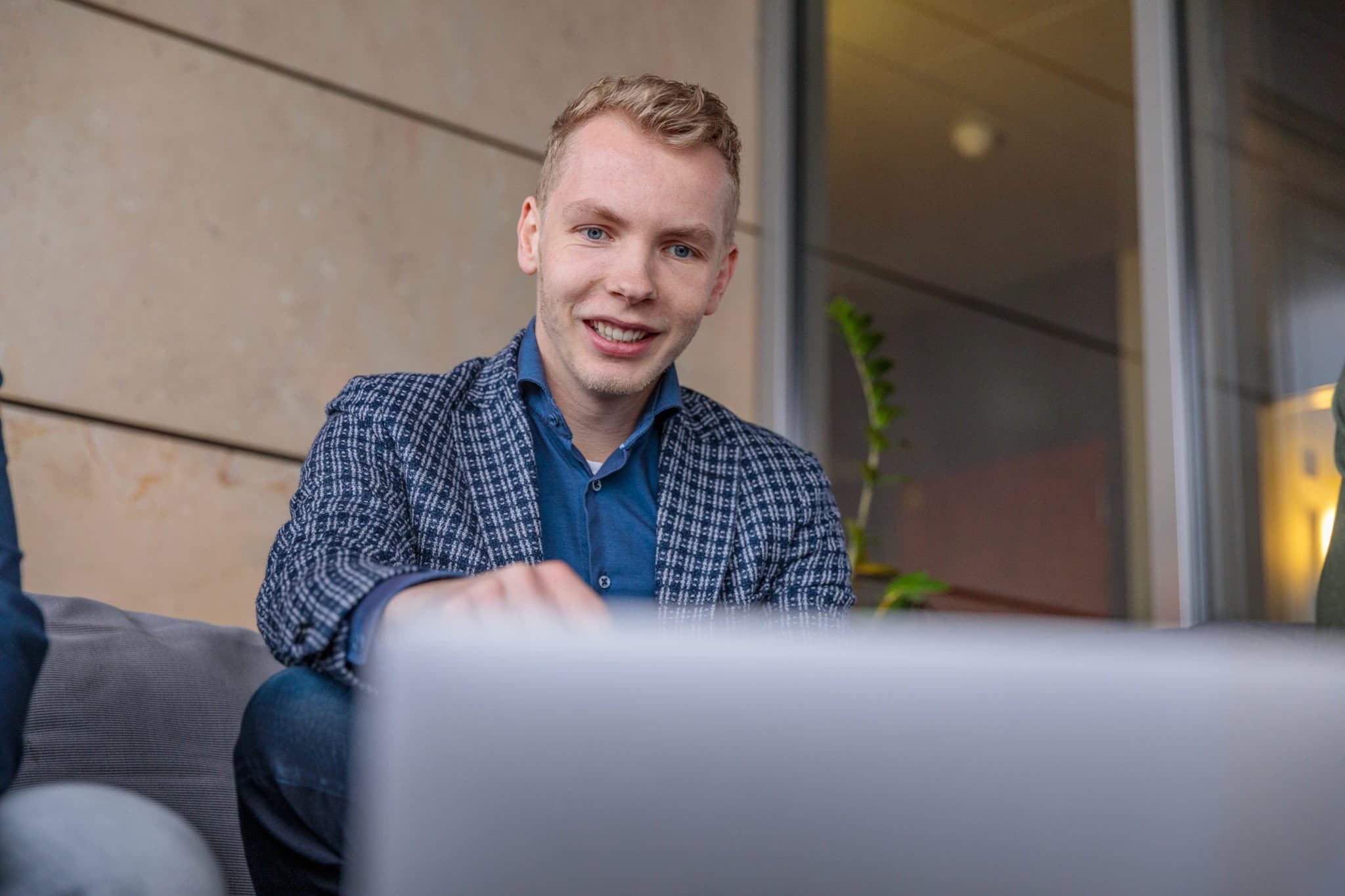 Een medewerker van Joinly aan het werk achter een laptop in het kantoor.